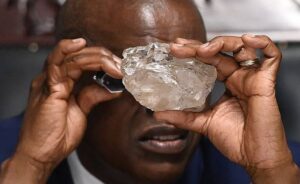 Botswana's President Mokgweetsi Masisi looks at the 2492 carat diamond discovered in the Karowe mine in Gaborone on August 22, 2024 (Monirul Bhuiyan/AFP)
